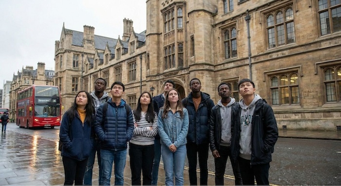 Diverse students outside UK university. / イギリスの大学前の多様な学生たち。